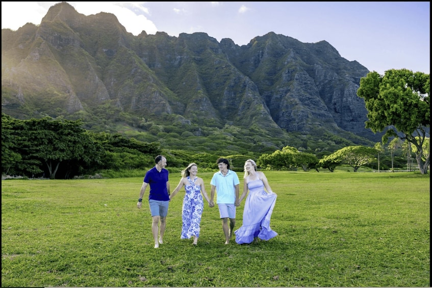 A group of people walking on a grassy field with a mountainous landscape in the background. 5