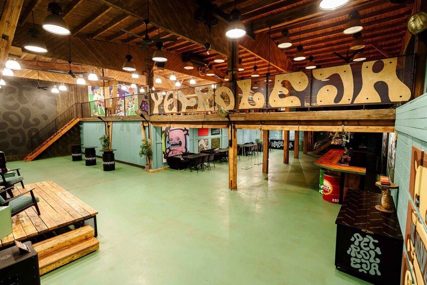 A wooden interior with a large sign reading 'YEPROO,' tables, chairs, and a staircase. 2