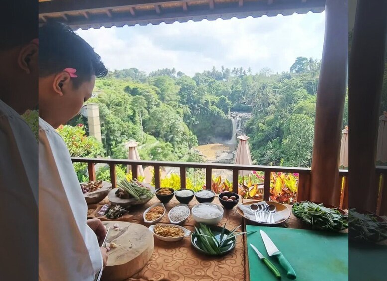 A person at a table with various food items and a scenic view of a waterfall and forest. 1