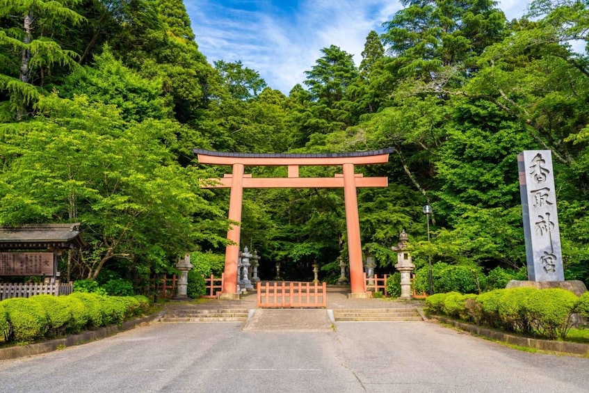 A traditional torii gate at the entrance of a shrine surrounded by lush greenery. 2