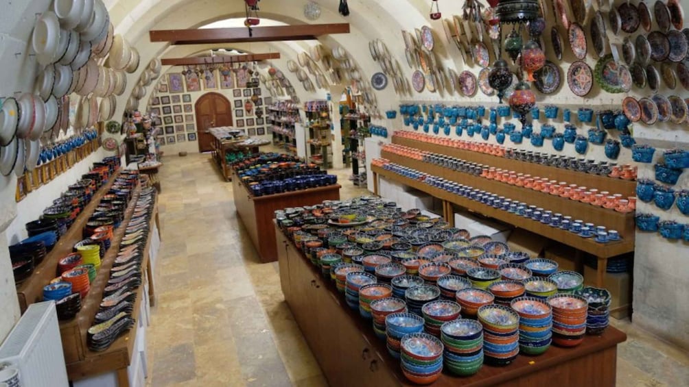 A pottery shop with shelves of colorful bowls and plates. 4