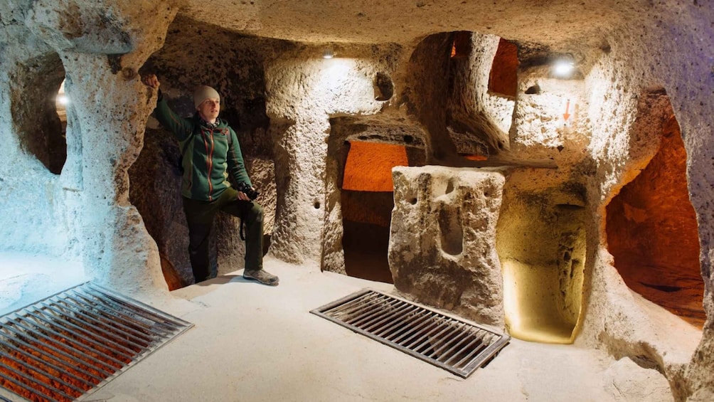 A person in a cave with a water feature and a light source. 5