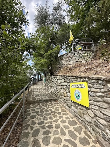 Stone steps leading up a hill with a yellow sign and a flag. 5