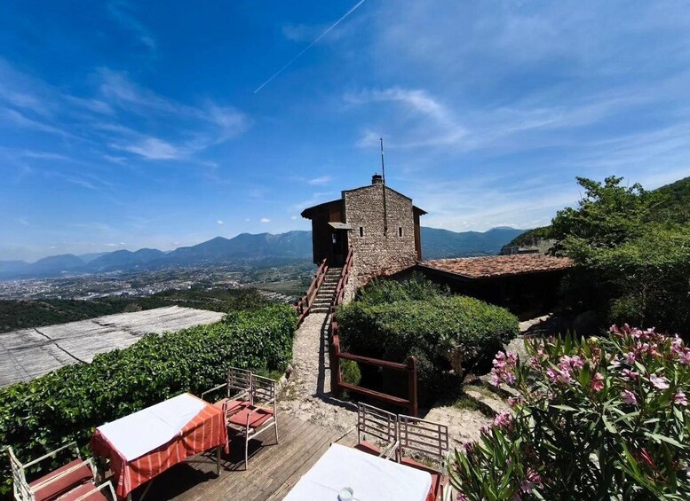 A stone tower with a staircase leading up to it, surrounded by greenery and overlooking a valley. 1