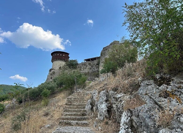 A stone staircase leading up to a tower on a hill with sparse vegetation. 3