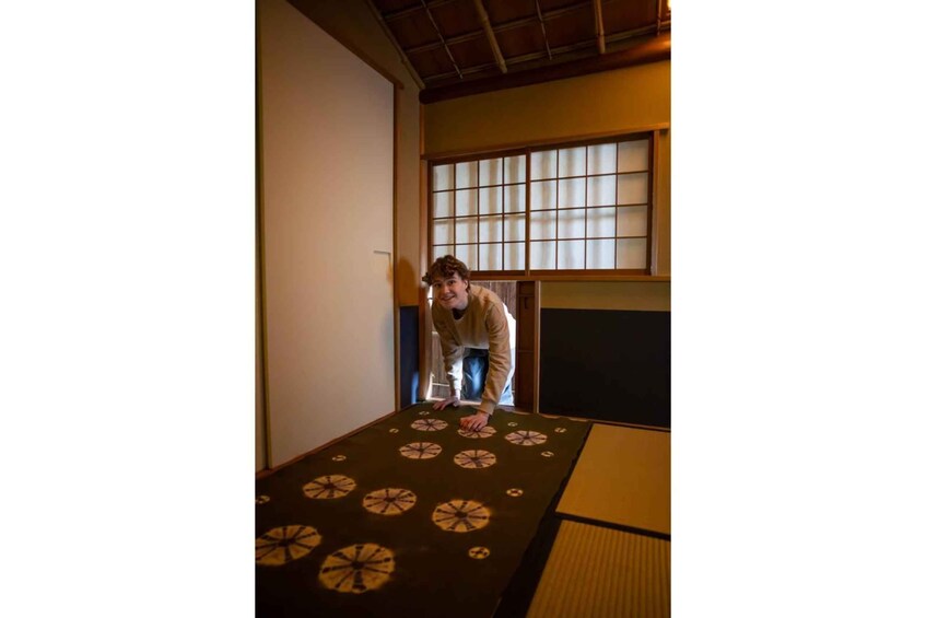 A person standing on tatami mats in a traditional Japanese room with shoji screens. 3