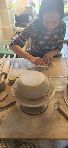A person shaping clay on a pottery wheel. 3