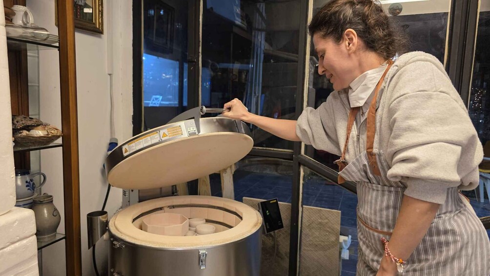 A person adjusting a large industrial oven with a control panel. 2