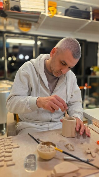 A person working with clay on a pottery wheel in a workshop. 1
