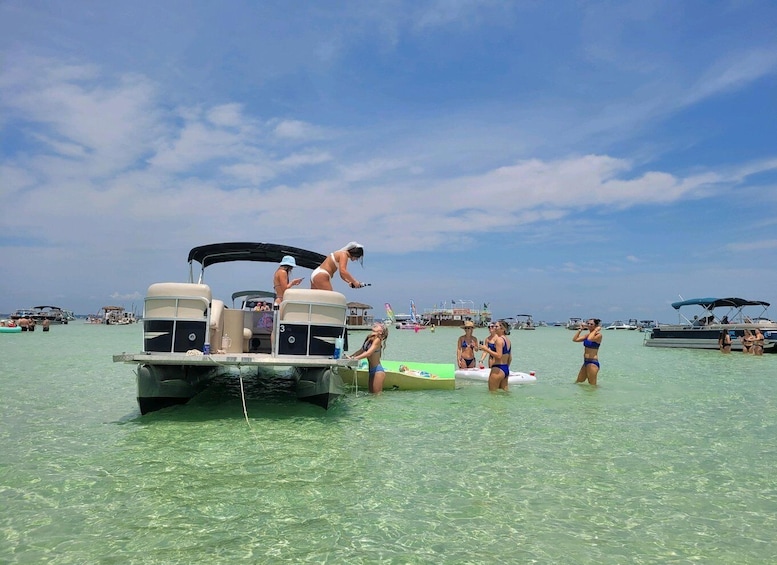 A boat with people on it, surrounded by clear water and other boats in the distance. 1