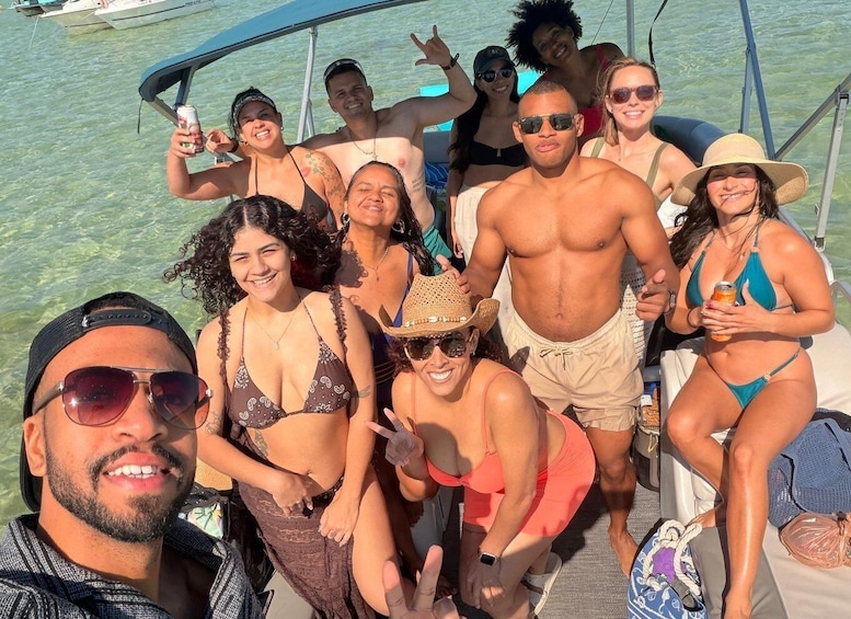 A group of people on a boat with clear water and a dock in the background. 2