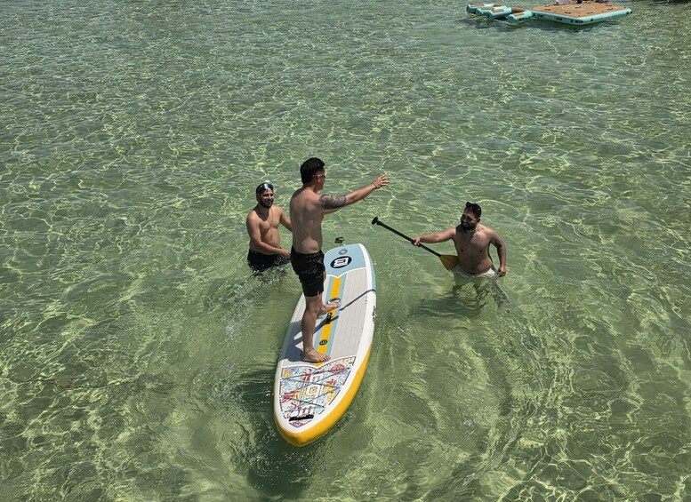 Three people paddleboarding in clear water. 5