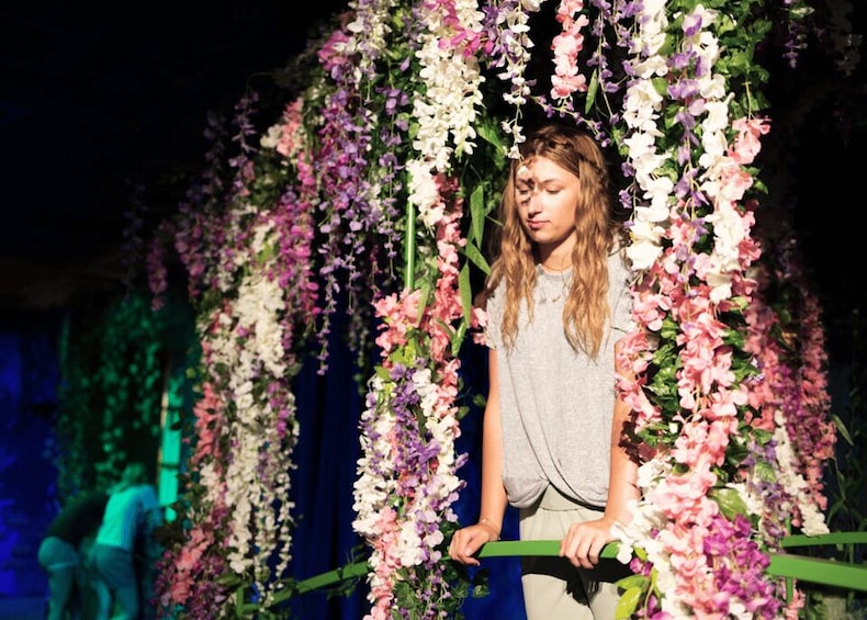 A person standing in front of a floral backdrop. 3