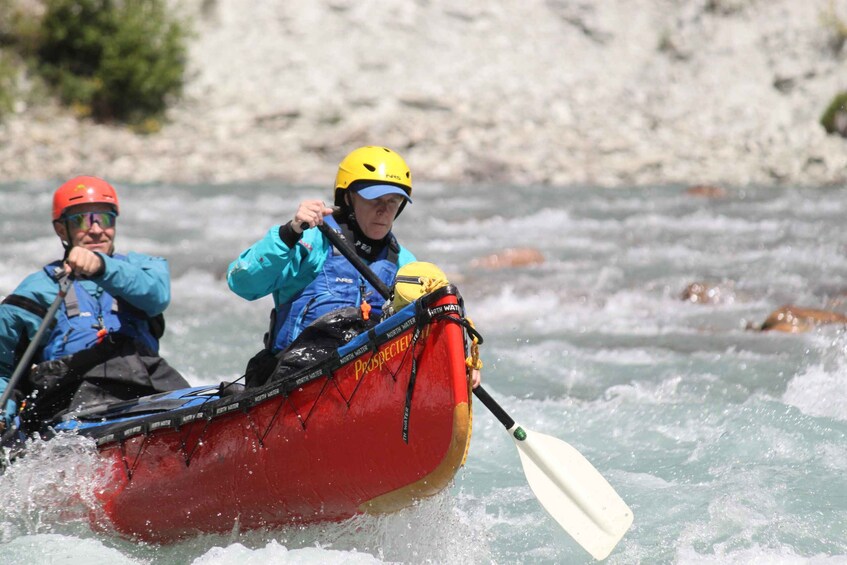 Two people in a red kayak on a river. 2