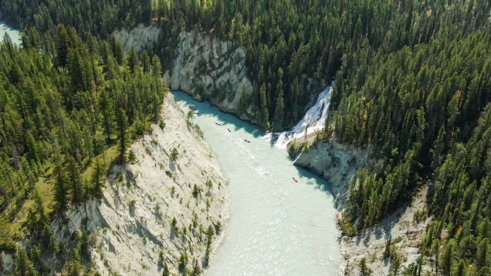 A river canyon with a waterfall and kayakers. 3