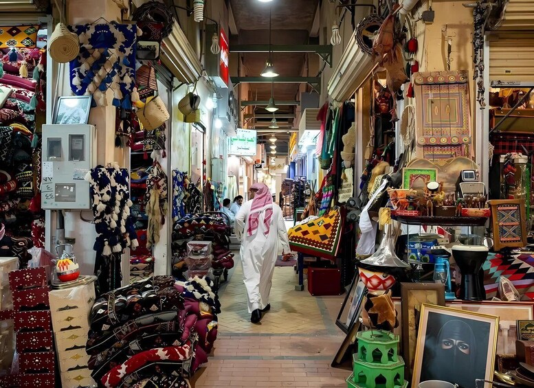 A narrow market with various stalls selling textiles and handicrafts. 2