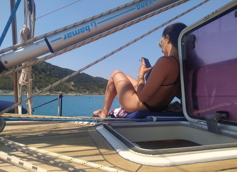 A person sitting on a boat deck, wearing a bikini, with a mountainous landscape in the background. 4