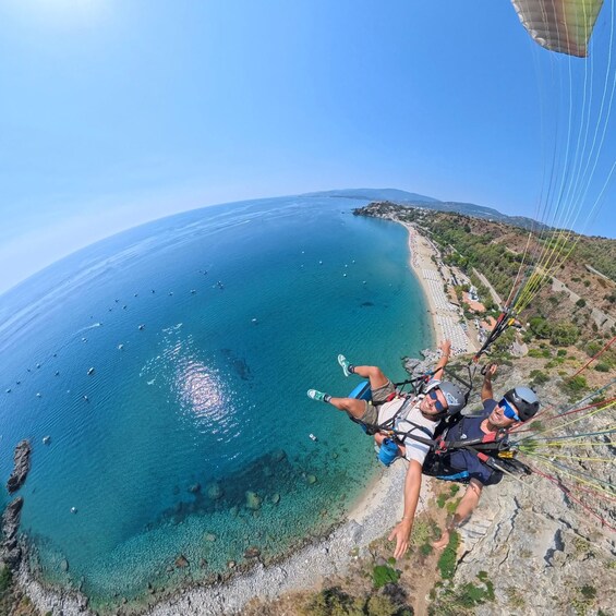A person skydiving over a coastal area with clear blue waters and a beach. 3