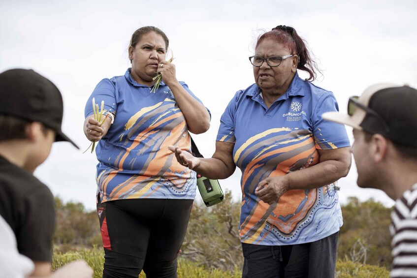 Two people in matching shirts with a logo, one holding a bottle and the other gesturing. 5