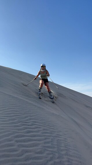 A person skiing down a sandy slope. 5