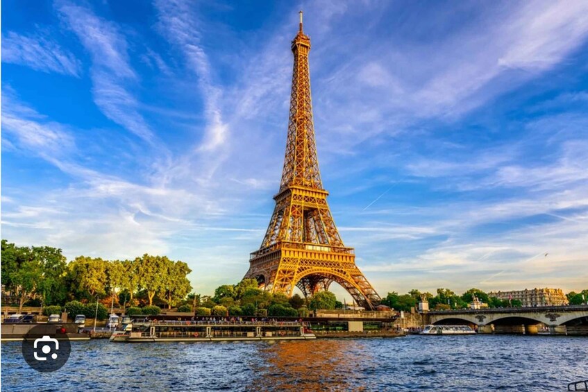 The Eiffel Tower with a river in the foreground and a bridge in the background. 1