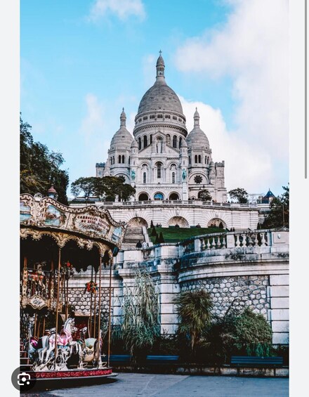 A grand building with domes and a carousel in the foreground. 5