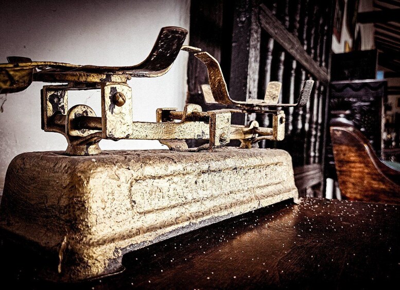 An old, rusted metal object with a lever and a wooden base, possibly a vintage tool or machinery part. 3