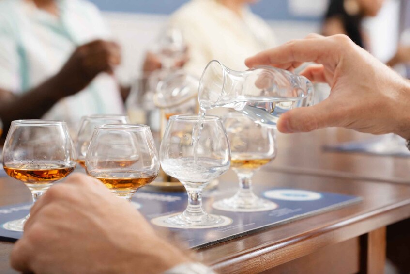 A person pouring a clear liquid into a glass. 3
