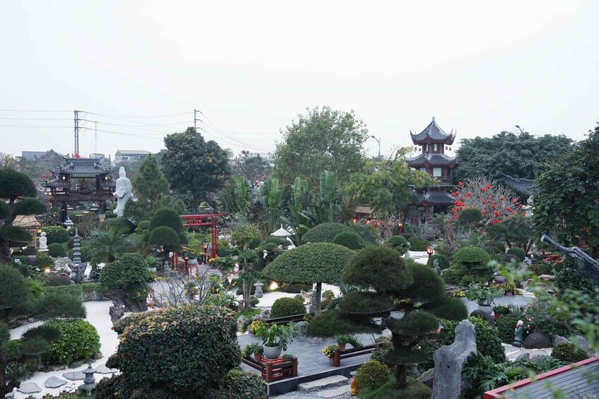 Un jardin chinois traditionnel, avec des pagodes, des lanternes en pierre et des arbres soigneusement taillés. 2