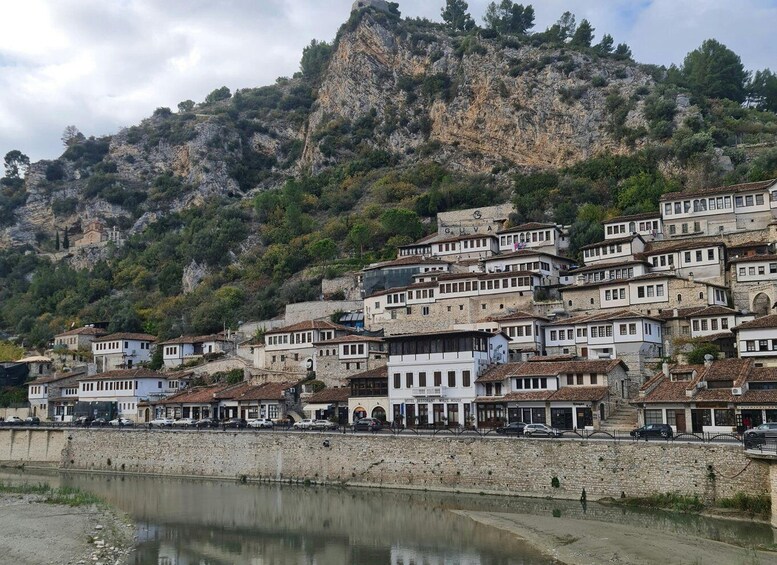 A coastal town with terraced buildings, a church, and a rocky cliff. 5