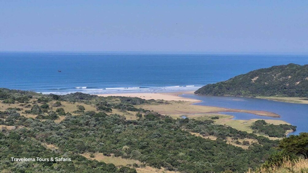 A coastal landscape with a beach, a bay, and dense greenery. 5