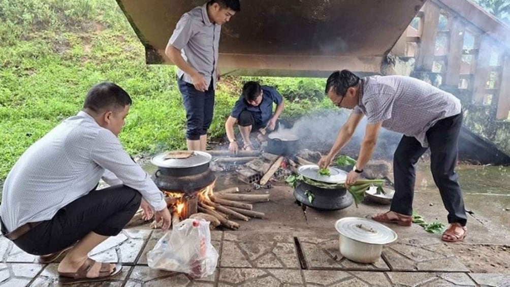 People cooking outdoors with pots over an open fire. 5