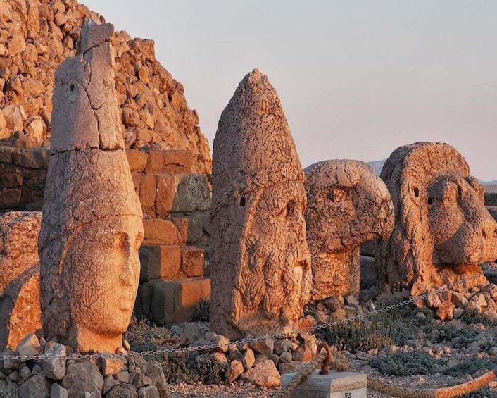 Ancient stone statues in a desert setting. 1