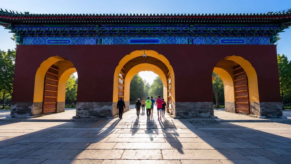 A traditional archway with a blue and red patterned roof, leading to a pathway. 5