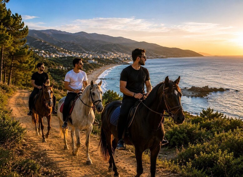 Three people riding horses on a coastal path with a view of the ocean and mountains in the background. 1