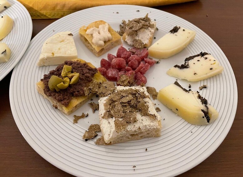 A plate with various food items including cheese, meat, and pickles. 5