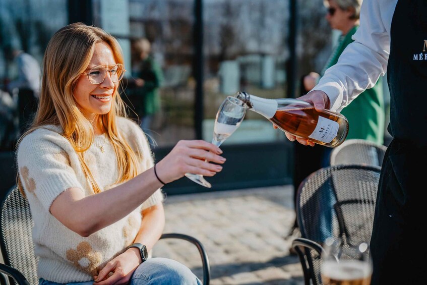 A person pouring a drink into a glass held by another individual. 3