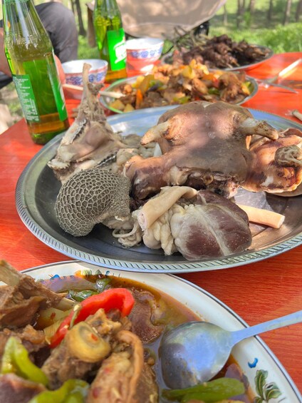 A meal with various dishes, including a large bone and a bowl of soup with vegetables. 3