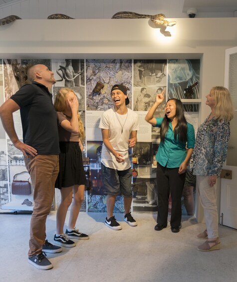 A group of people in an indoor exhibition space with various displays and informational panels. 3