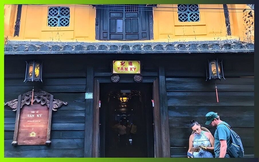 A traditional building with a sign reading 'TANK KY' and a wooden plaque with text. 3