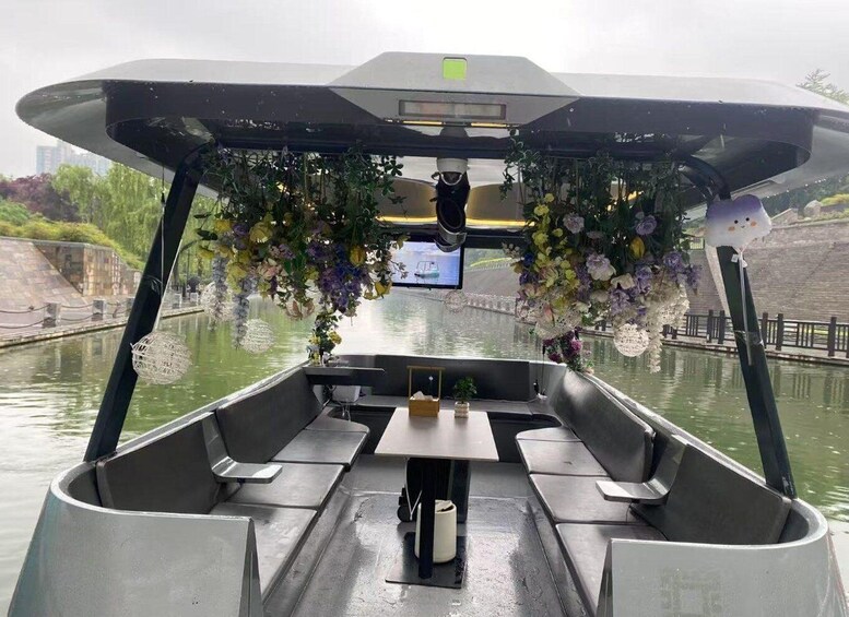 A boat with a digital screen, seating, and decorative flowers. 2
