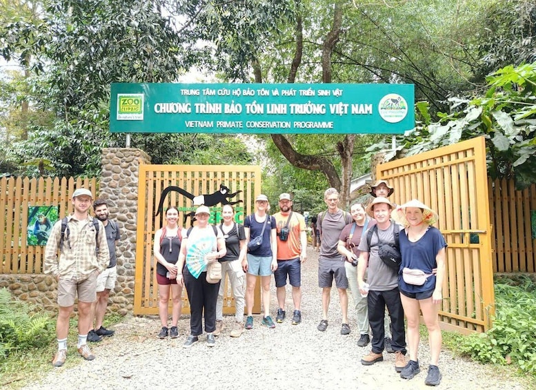 A group of people standing in front of a sign for the Vietnam Primate Conservation Programme. 4