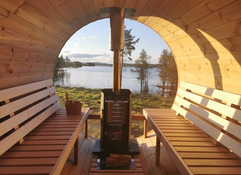 A wooden sauna with a view of a lake and trees. 3