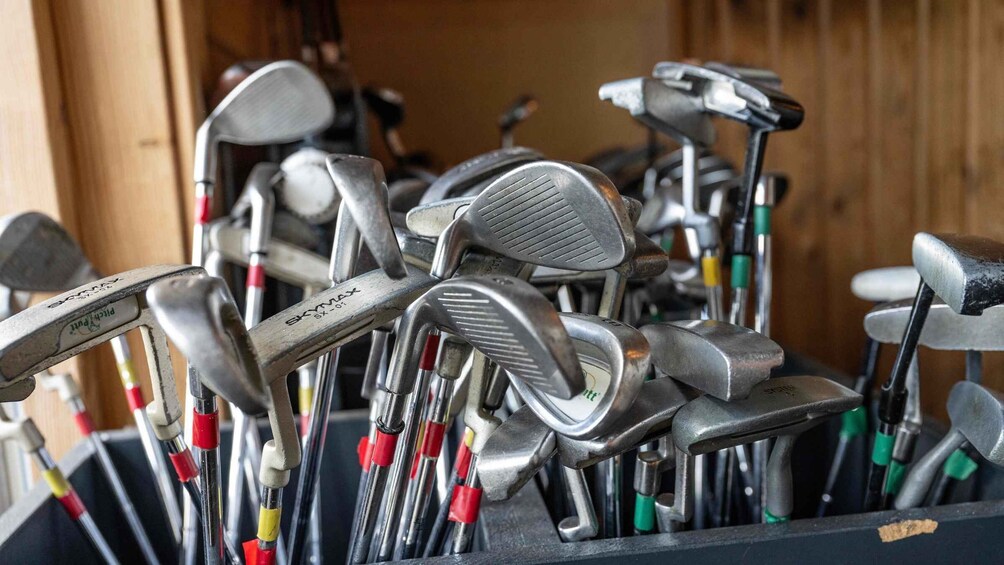 A collection of golf clubs in a storage rack. 2
