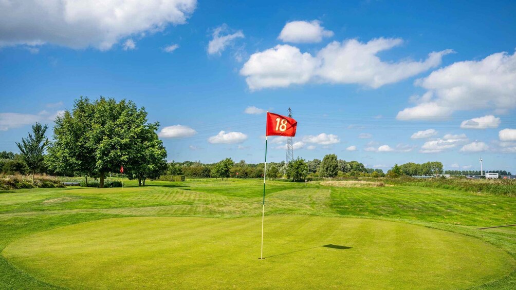 A golf course with a flag marked '18' on a tee box. 4