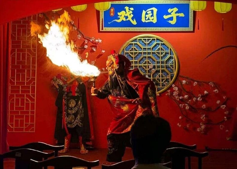 A performer with a flaming prop in a traditional costume, a red backdrop, and a decorative window. 1