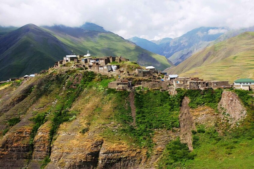 Ein Bergdorf mit traditionellen Häusern, die auf einer Klippe thronen. 5