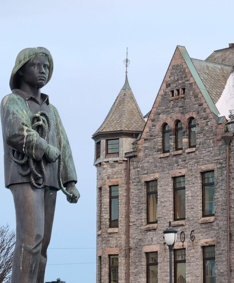 A statue of a person with a rope, a stone building with a pointed roof, and the number '106' on the wall. 2