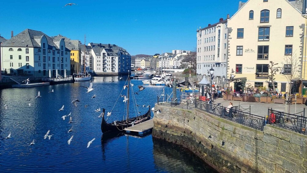 A harbor with boats, seagulls, and buildings along the waterfront. 3