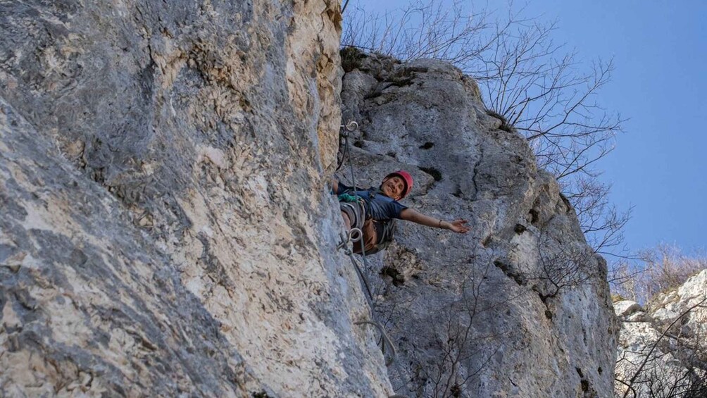 A person climbing a rocky cliff. 3
